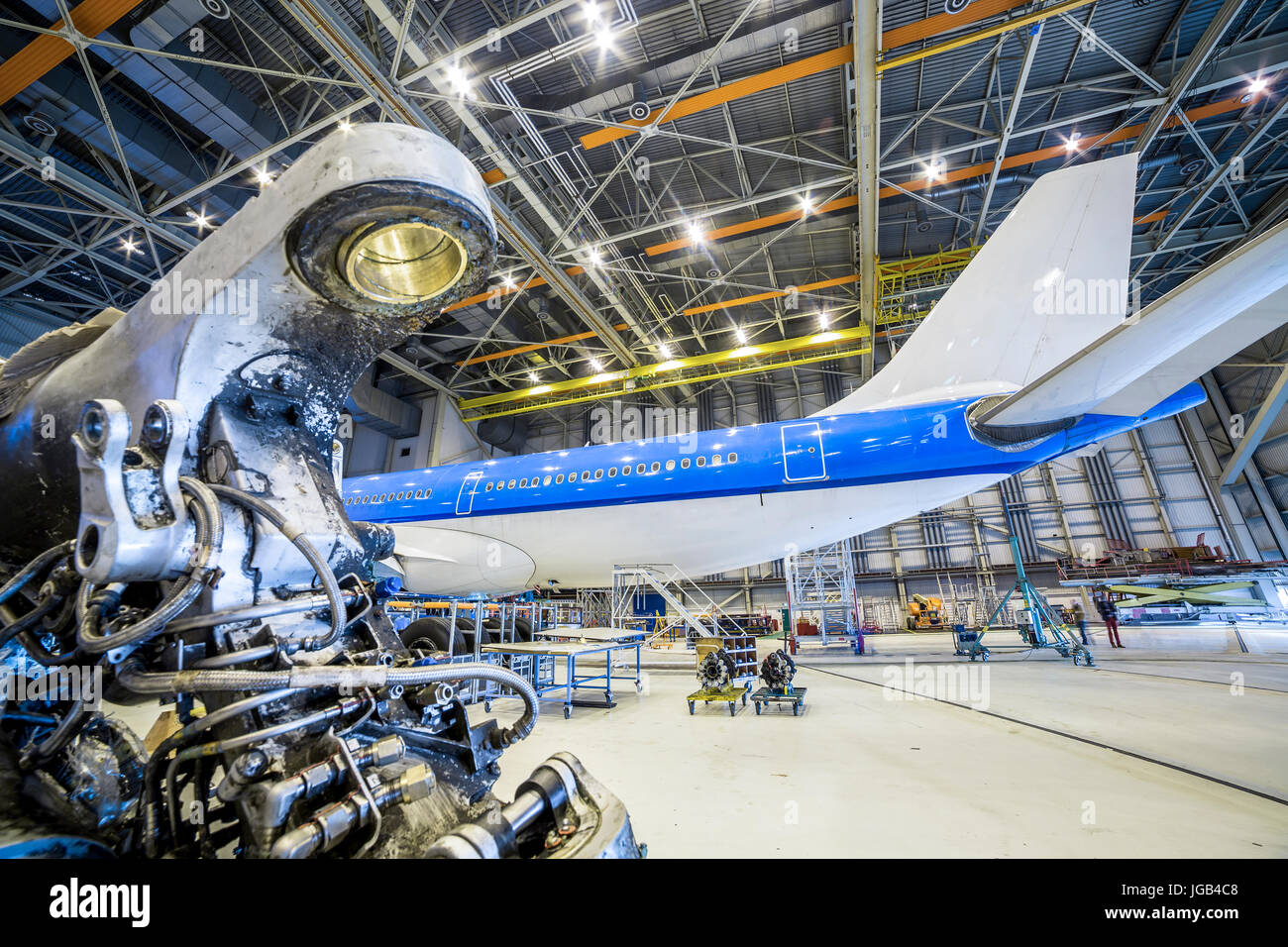 Refurbishment of white and blue airplane in a hangar. Stock Photo