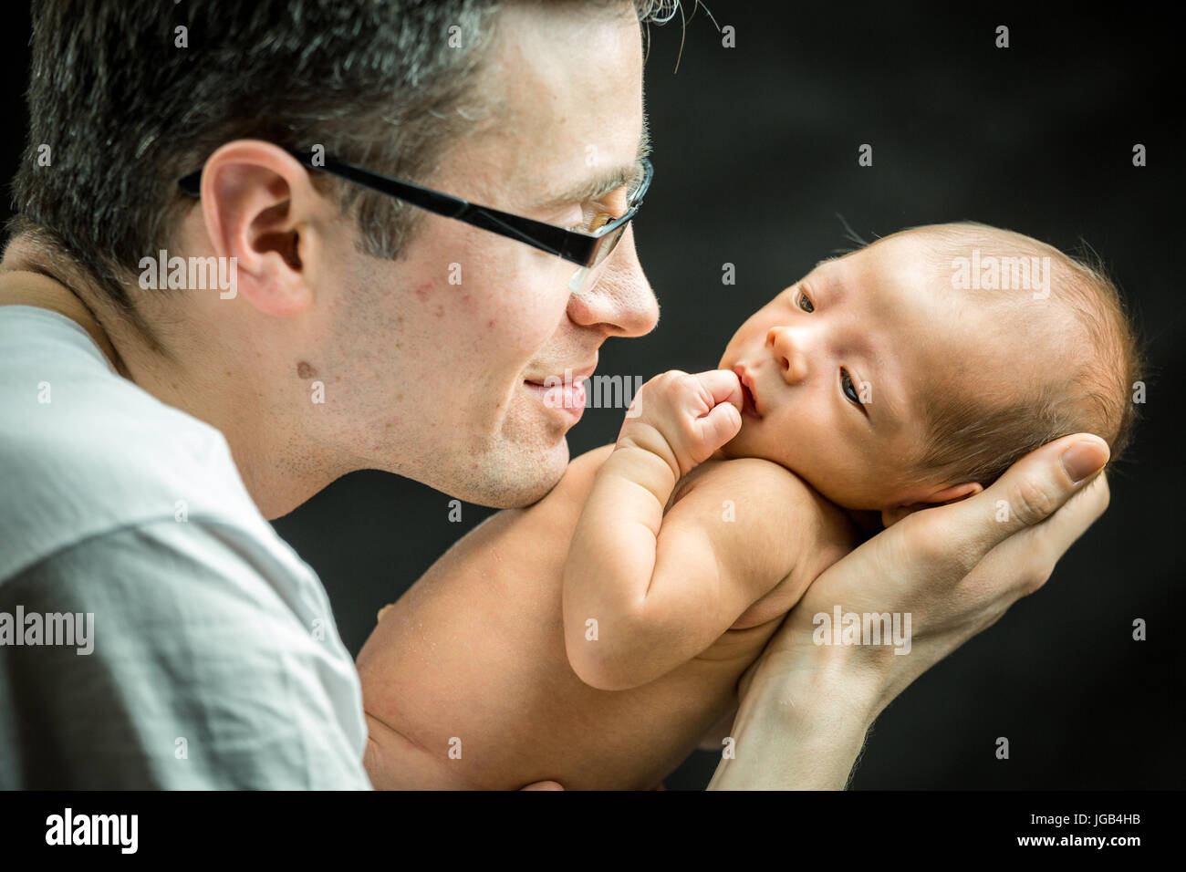 Happy father holding with love his 3 weeks old son Stock Photo