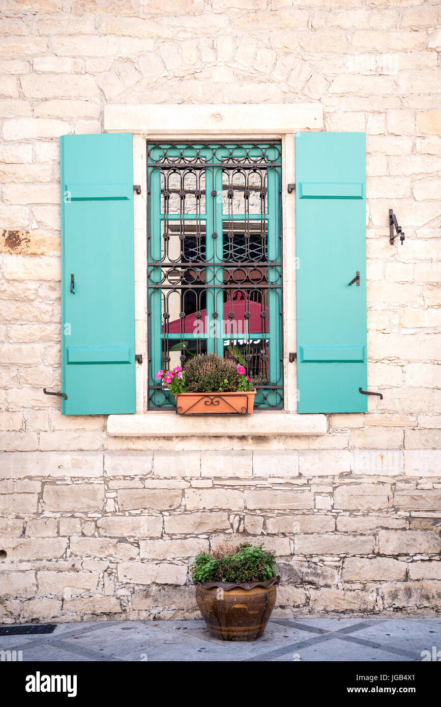 Cute window with blue shutters and flowers, Cyprus Stock Photo