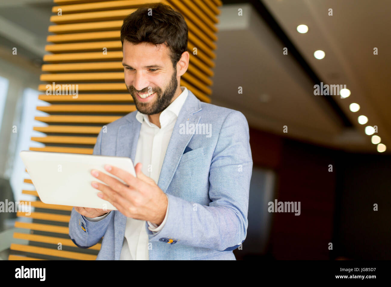 Businessman using tablet computer in modern office Stock Photo - Alamy