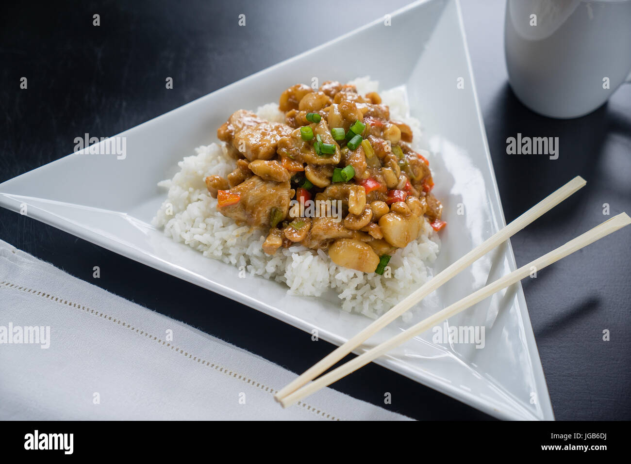 Plate of Kung Pao Chicken on white plate with chopsticks. Stock Photo