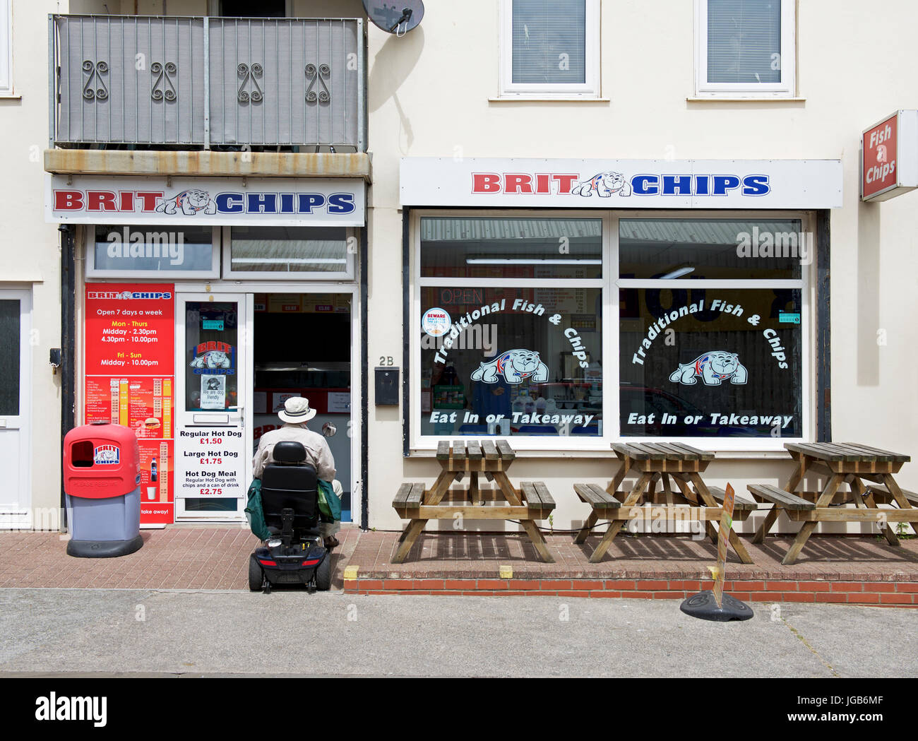 Senior man on mobility scooter, entering fish & chip shop, BurnhamonSea, Somerset, England UK