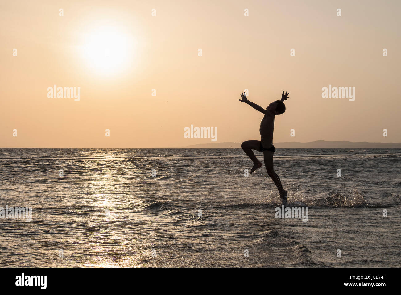 Boy running with joy on the water. Stock Photo