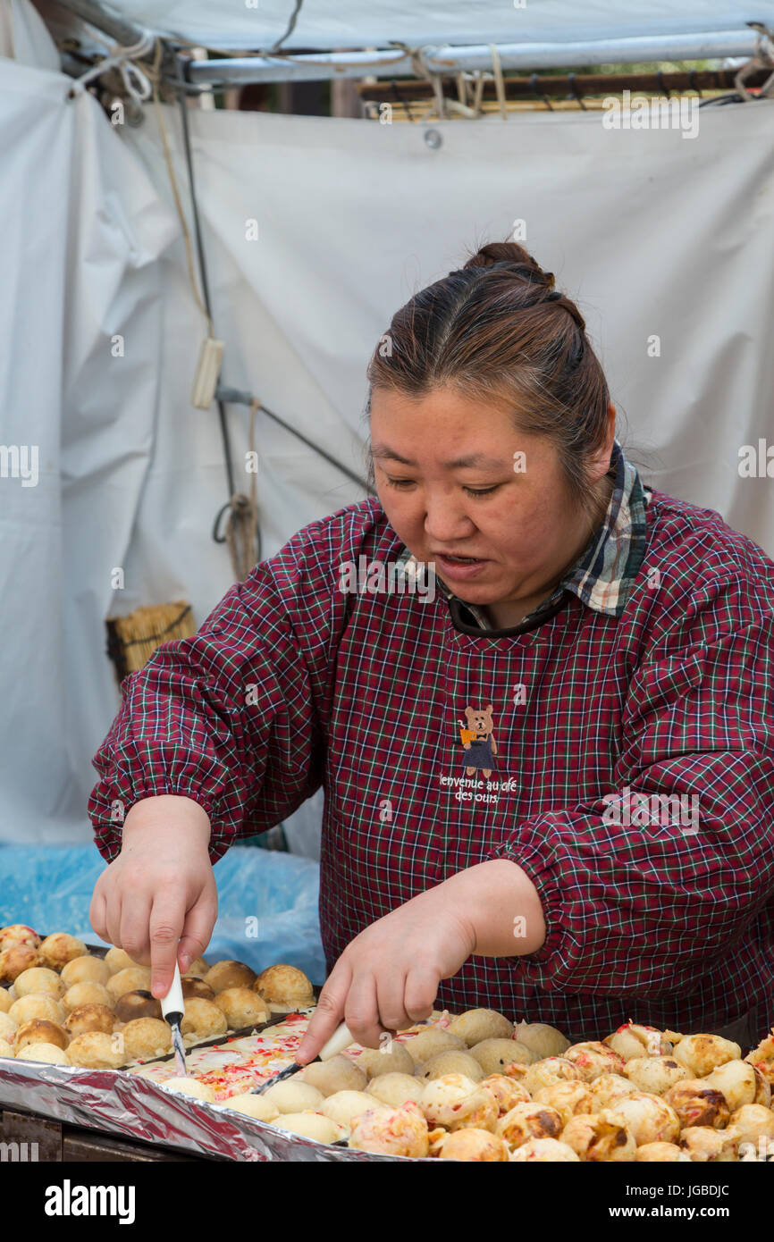 A street food vendor preparing traditional Japanese dishes in Asakusa
