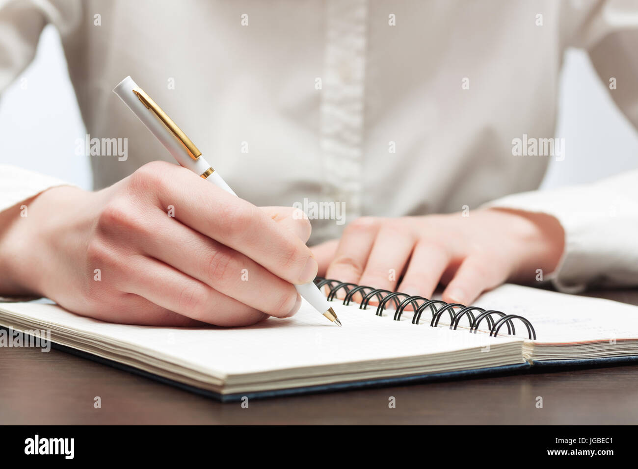 Business woman writing in notebook Stock Photo - Alamy