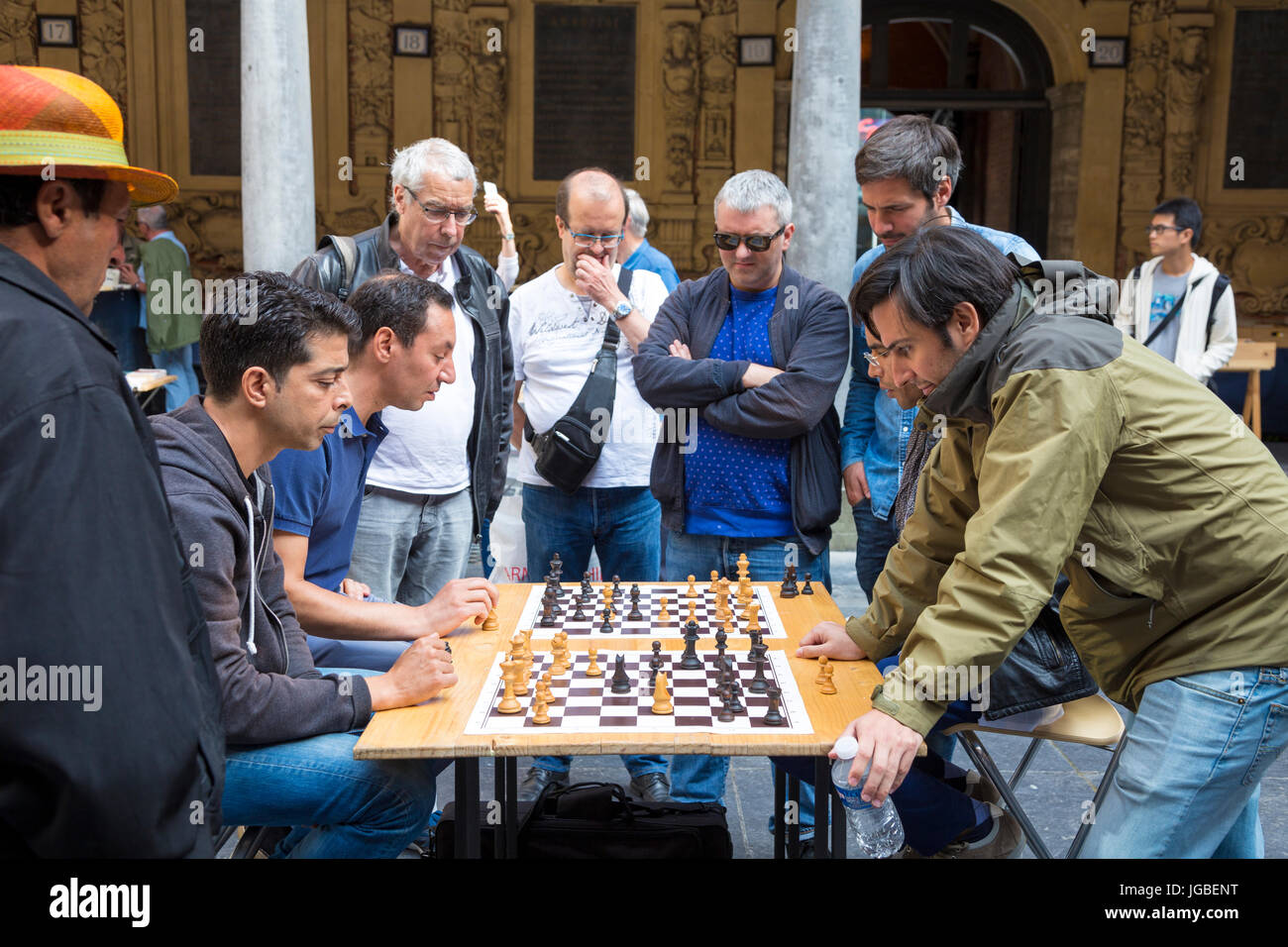 Group of men playing chess whilst others watching in the courtyard of La Vieille Bourse (Old Stock Exchange) in Lille, France Stock Photo