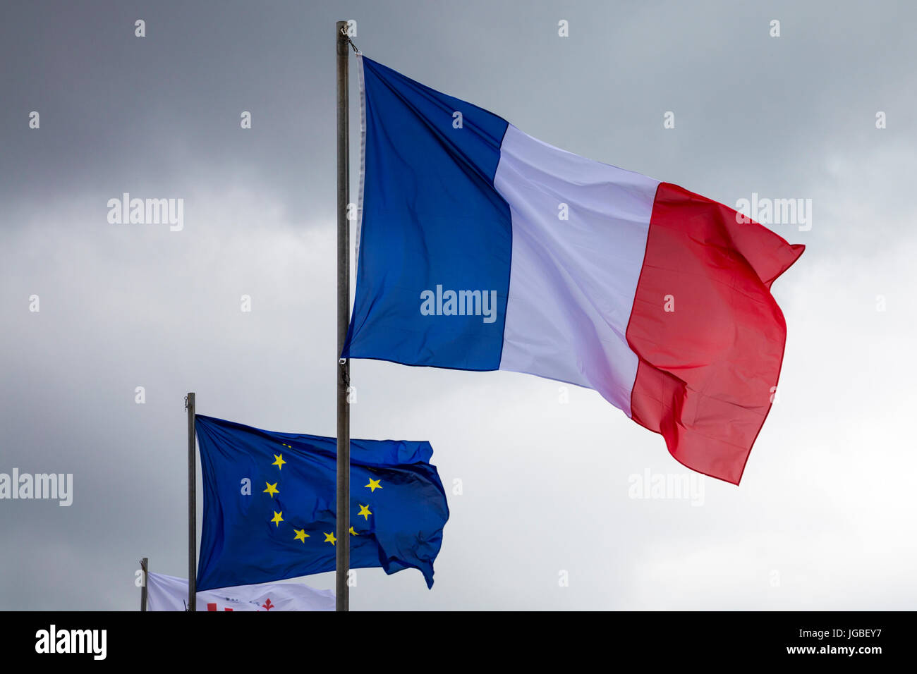 French and EU flag against an overcast sky Stock Photo