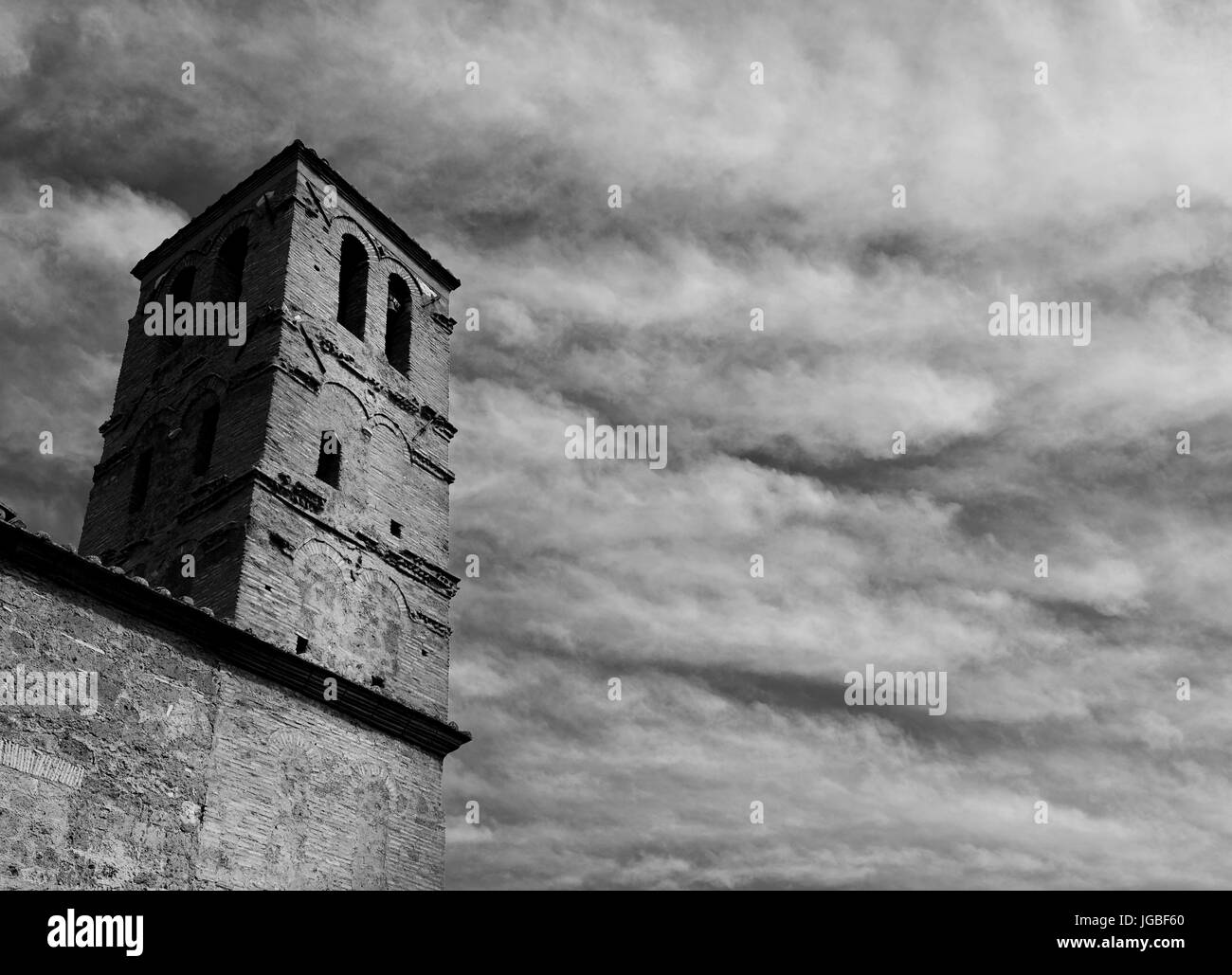Medieval belfry of the Church of San Giuliano with clouds, in the center of the ancient ruined of Faleria, a small city near Rome (Black and White) Stock Photo