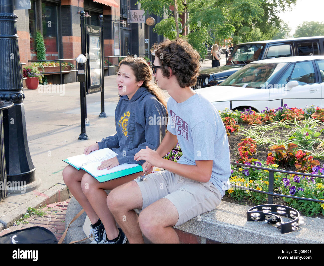 Young woman singing while young man plays the spoons. Old Market District, Omaha, Nebraska. Stock Photo