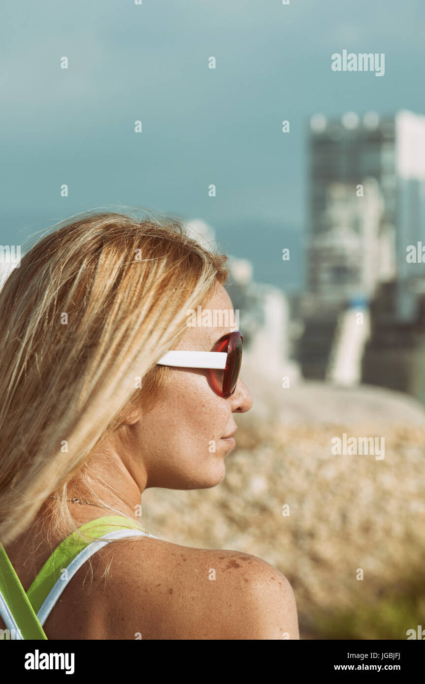 Rear view of a woman wearing sunglasses looking away outdoors Stock ...