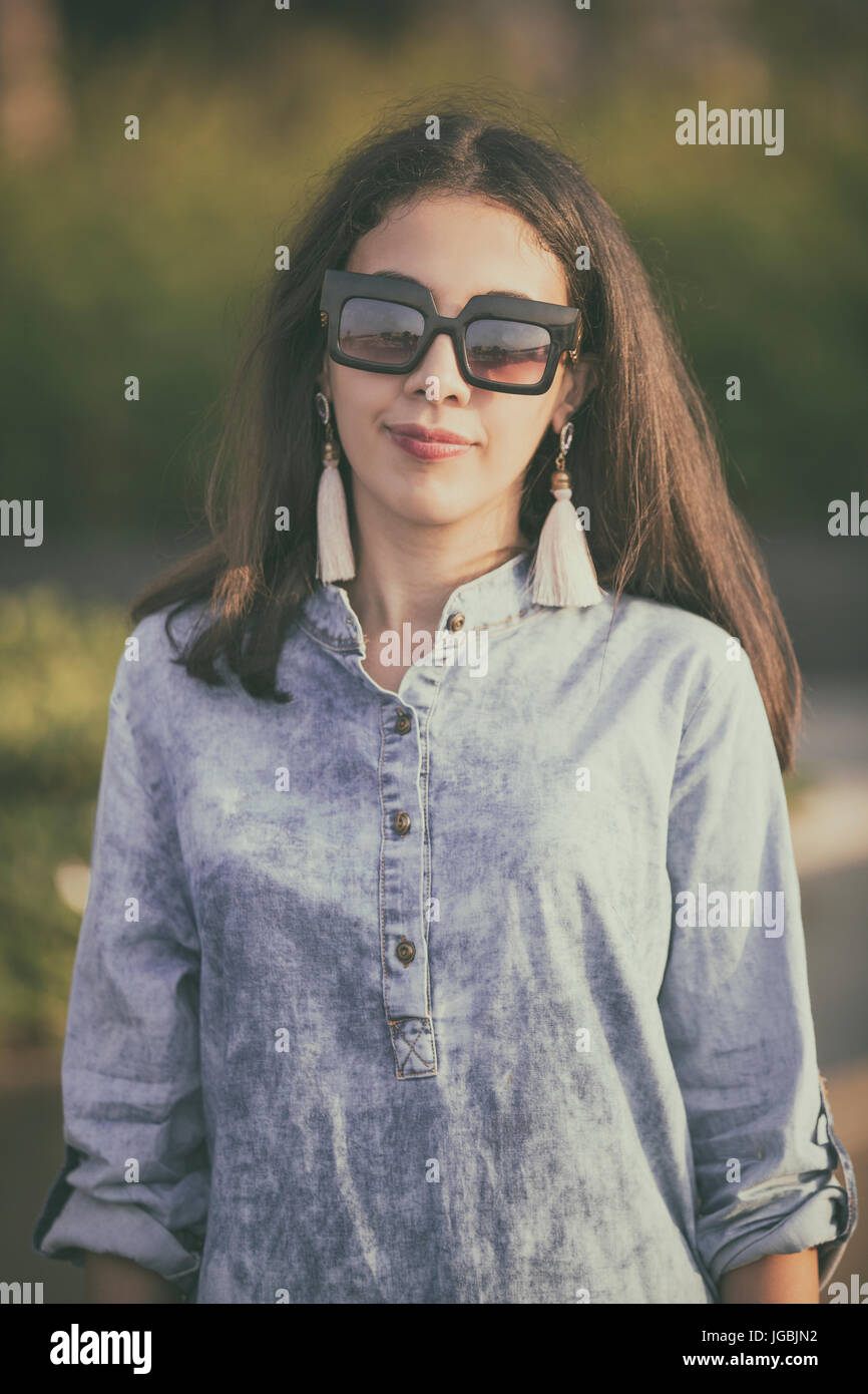 Portrait of a beautiful young woman wearing suinglasses outdoors Stock Photo
