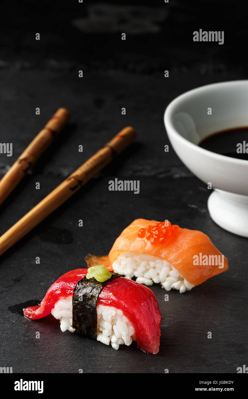 Red tuna Nigiri with Nori seaweed and wasabi paste on black slate stone