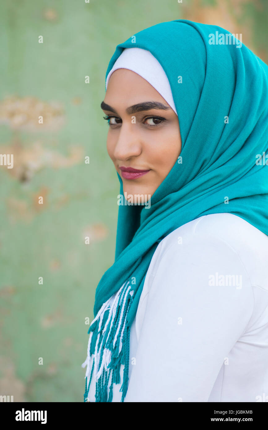 Portrait of a beautiful young Muslim woman wearing headscarf smiling ...
