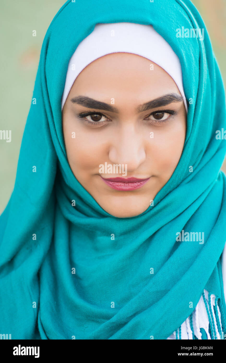 Portrait of a beautiful young Muslim woman wearing headscarf staring ...
