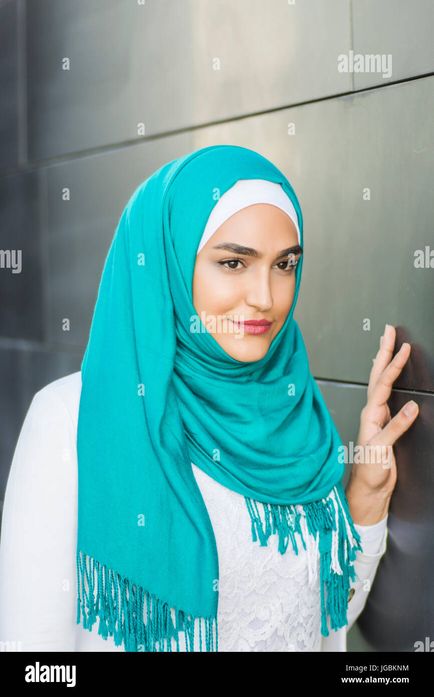 Portrait of a beautiful young Muslim woman wearing a green headscarf ...
