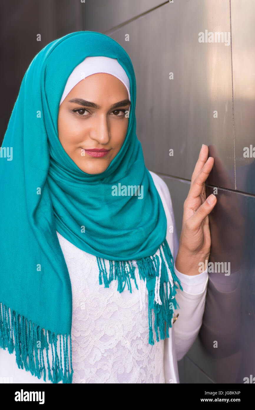 Portrait of a beautiful young Muslim woman wearing a green headscarf ...