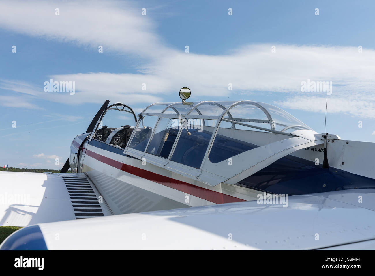 Two seat single engine civil utility aircraft, white small plane, red and blue strip is towed by a glider on a sunny day. Stock Photo