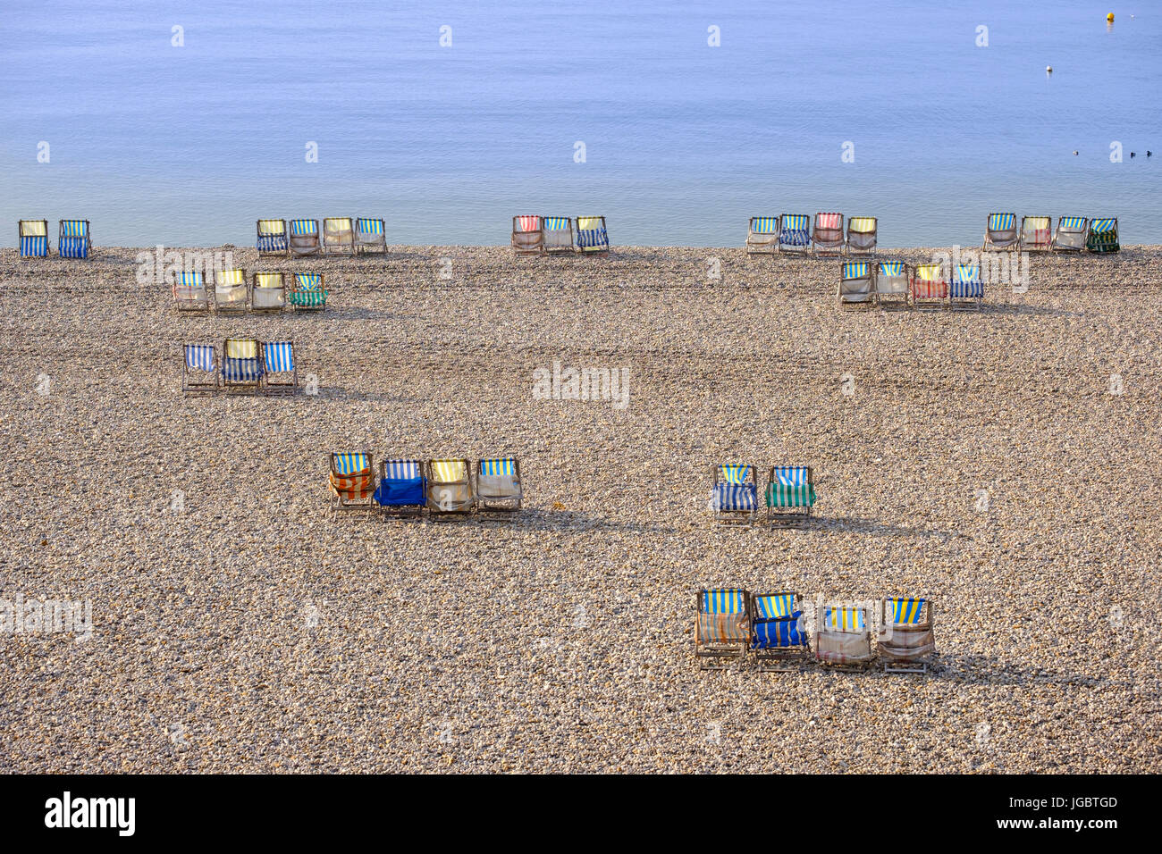 Colorful canvas chairs at the shingle beach, Beer, Jurassic Coast, Devon, England, United Kingdom Stock Photo