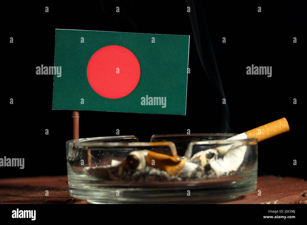 Bangladesh flag with burning cigarette in ashtray isolated on black