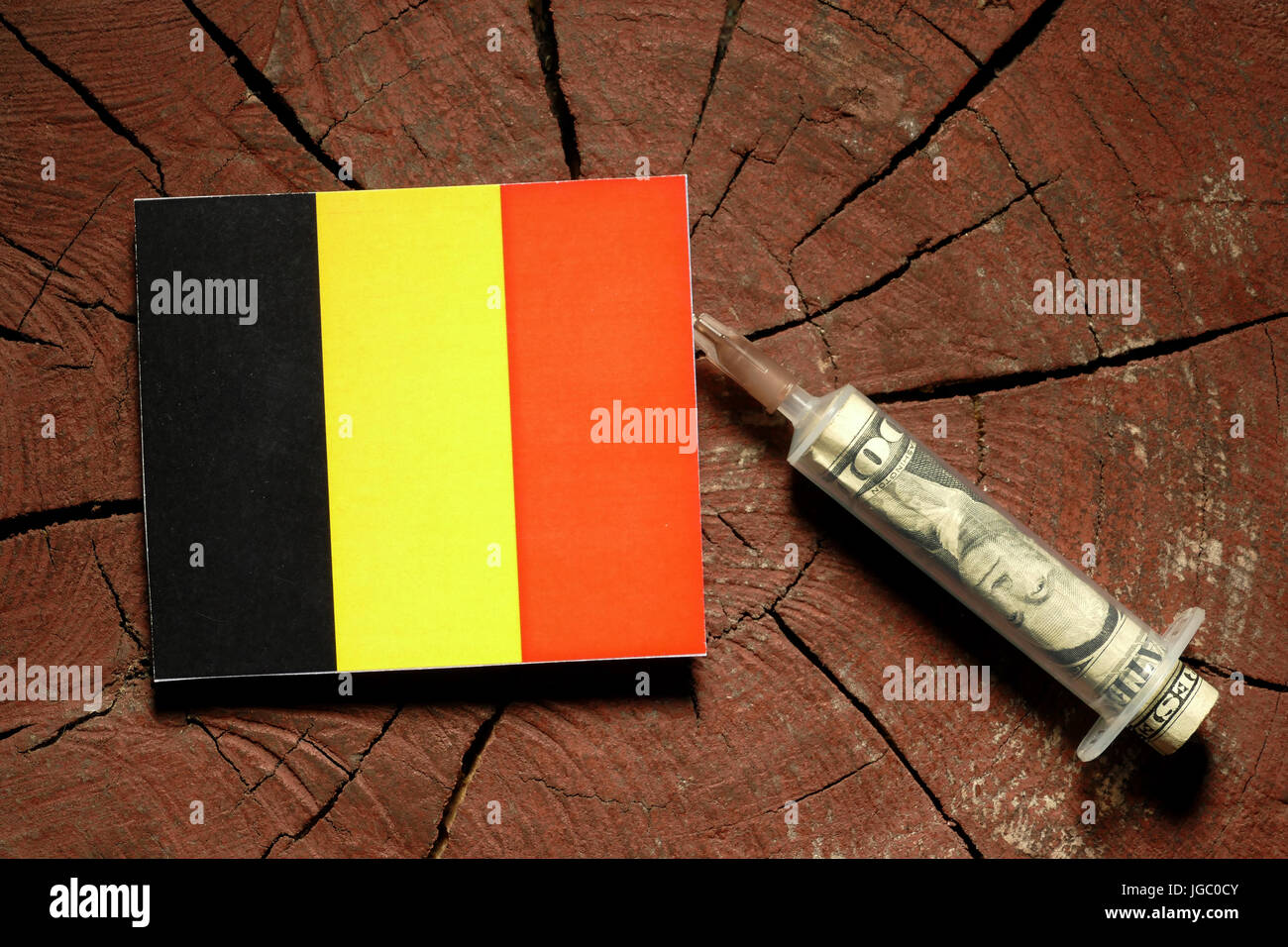 Belgian flag on a stump with syringe injecting money in flag Stock Photo