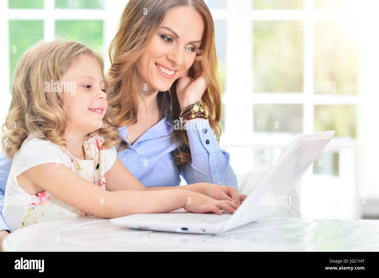 woman and little girl using laptop Stock Photo - Alamy
