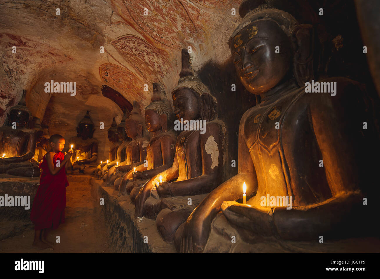 Monk praying with candle light at Po Win Taung / Hpowindaung cave - Monywa - Sagaing region - Northern Myanmar Stock Photo