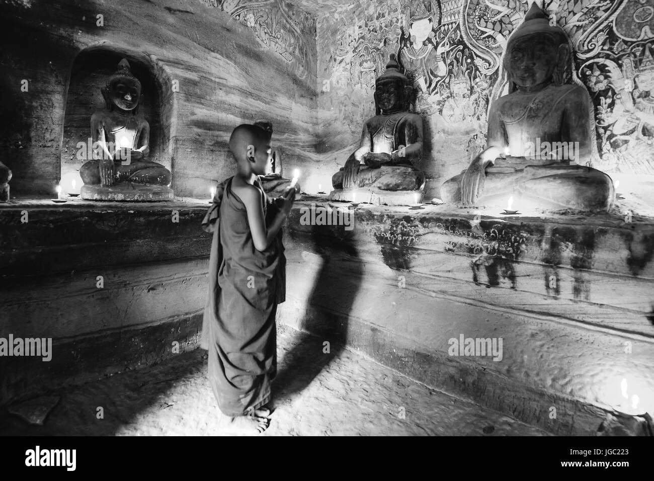 Monk praying with candle light at Po Win Taung / Hpowindaung cave - Monywa - Sagaing region - Northern Myanmar Stock Photo