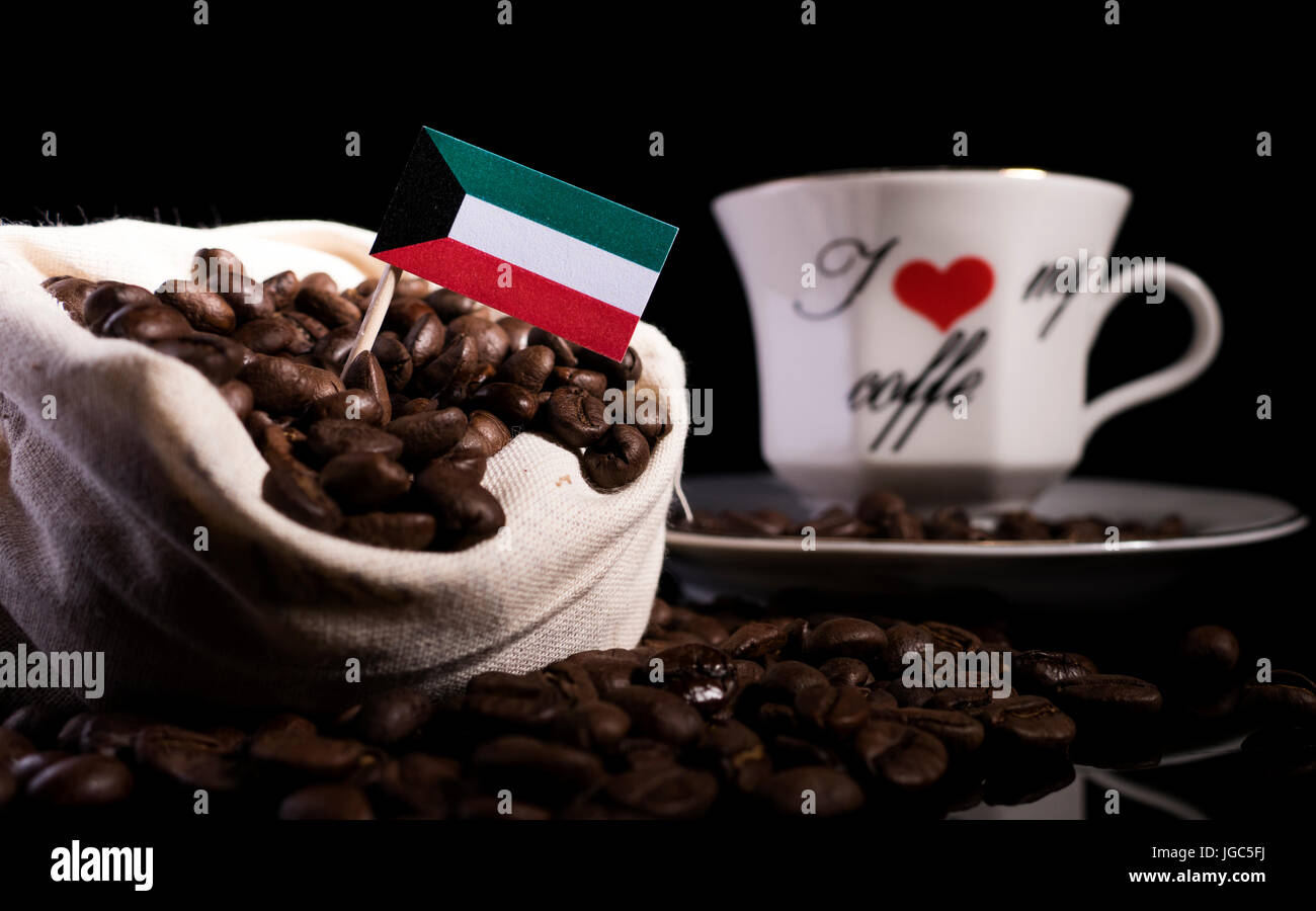 Kuwaiti flag in a bag with coffee beans isolated on black background Stock Photo