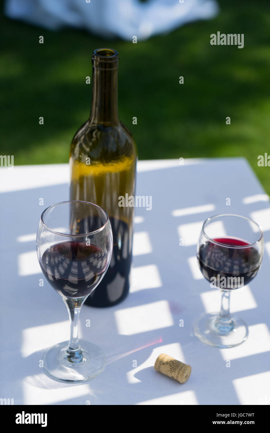 Red wine and bottle outdoors on a table Stock Photo