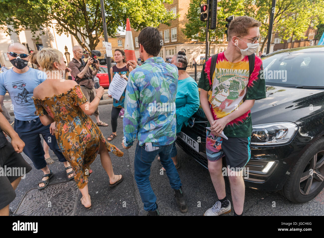 London, UK. 5th July 2017. Rising Up campaigners dance on the Marylebone Road   in their brief 'Stop Killing Londoners - Cut Air Pollution' road-block disco on the east-bound carriageway near Baker St to raise awareness about the terribly high pollution levels on London streets caused largely by traffic. They walked onto a pedestrian crossing, raised a banner, spoke briefly about the problem and then danced, holding up notices to the blocked motorists apologising  for the protest but pointing out that urgent action was needed and the protest would be short. One Volvo driver got out of his car  Stock Photo