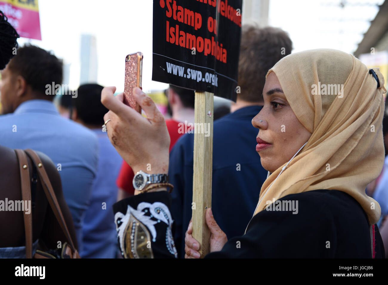 London, UK. 05th JUL 2017. 'STOP ACID ATTACKS' emergency protest outside the Stratford station in East London. Protesters gathered to protest against the recent acid attacks and increasing Islamophobia. Muslim woman is filming the protest with mobile phone. Credit: ZEN - Zaneta Razaite / Alamy Live News Stock Photo