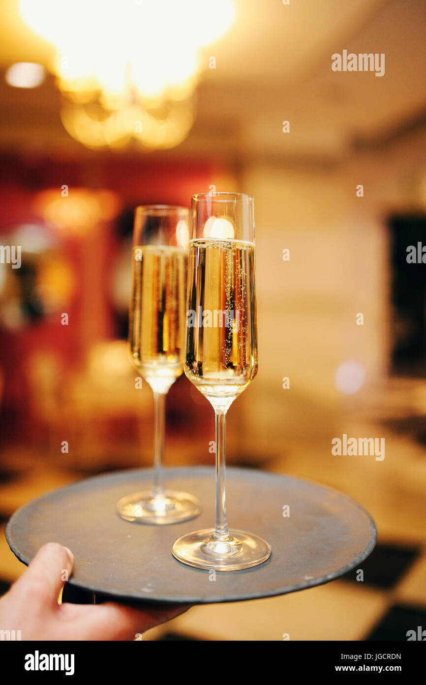 Man carrying a tray with two glasses of champagne Stock Photo Alamy
