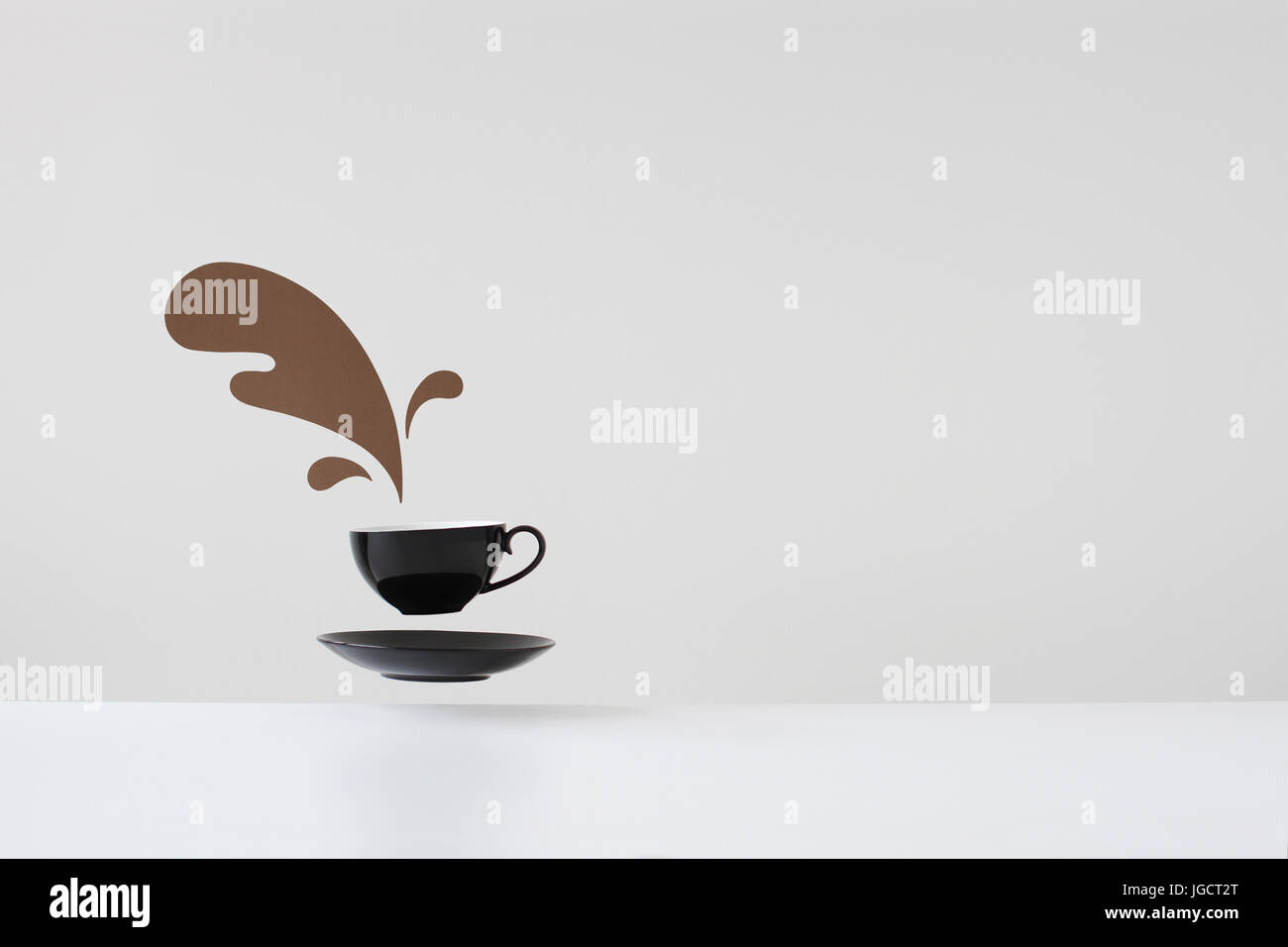 Conceptual spilled coffee from floating cup and saucer Stock Photo