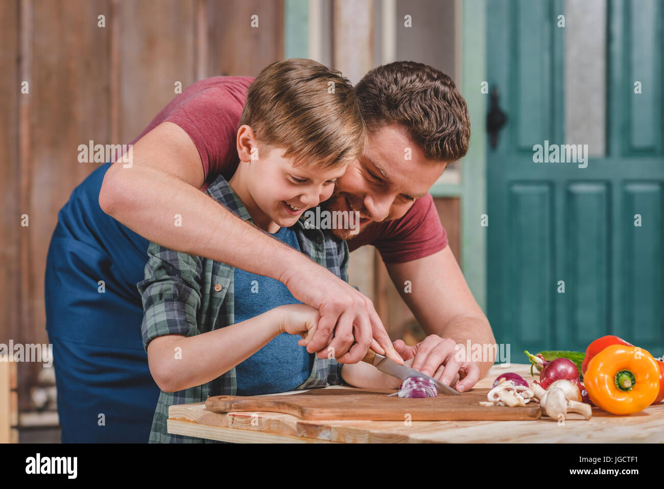 father with little son preparing food on table at backyard, dad and son cooking Stock Photo