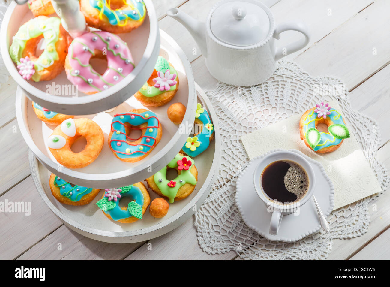 Delicious donuts served with coffee on white table Stock Photo - Alamy