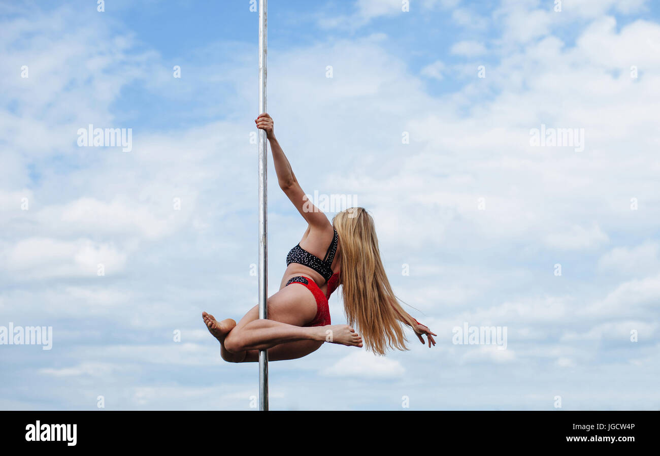 Woman pole dancing outdoors Stock Photo