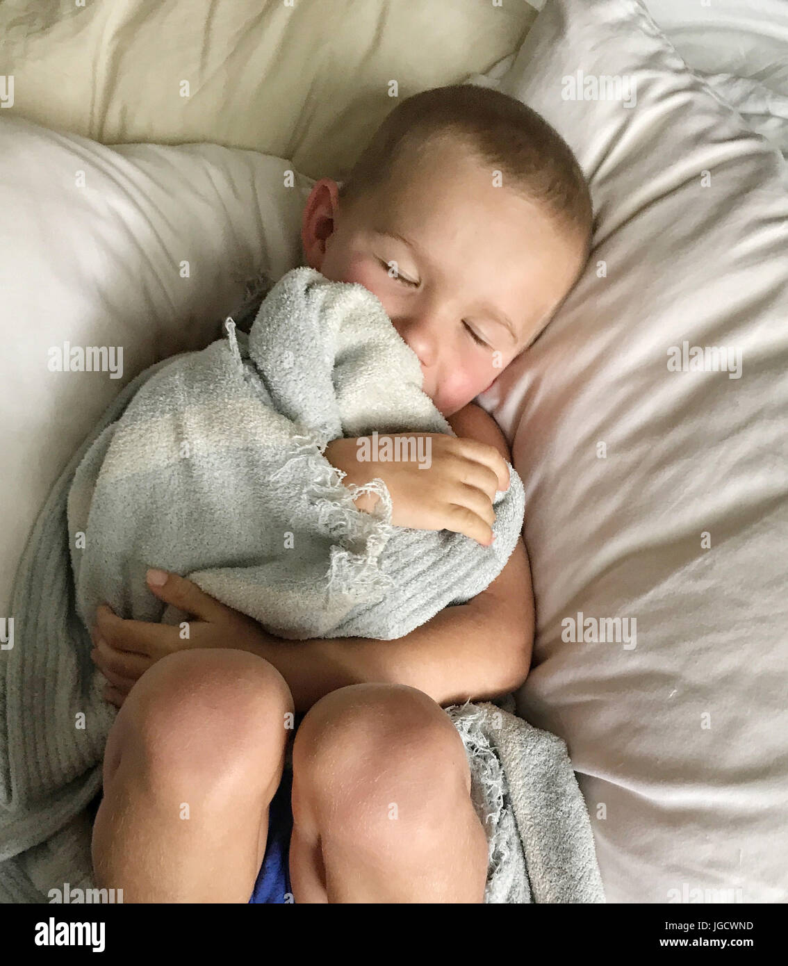 Overhead view of a boy sleeping with his blanket Stock Photo