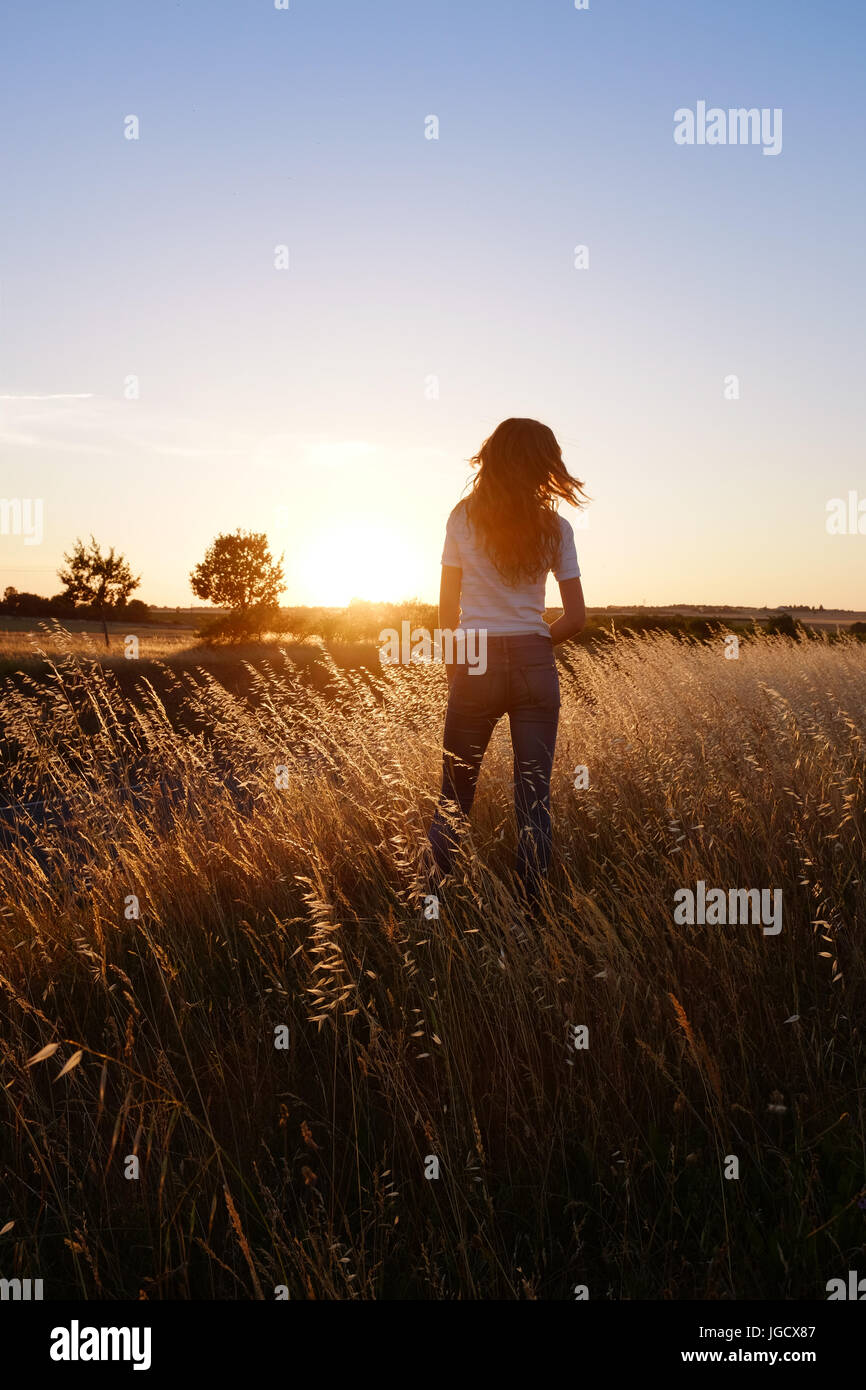 Girl standing in a meadow at sunset, Niort, France Stock Photo - Alamy