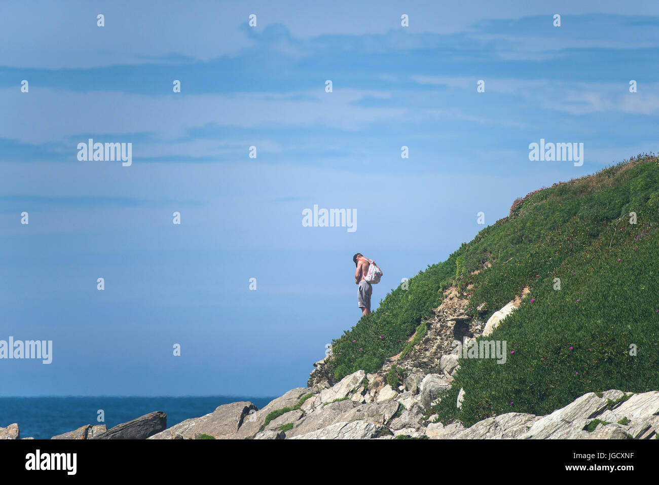 A man standing on the Headland at Fistral in Newquay, Cornwall. Stock Photo