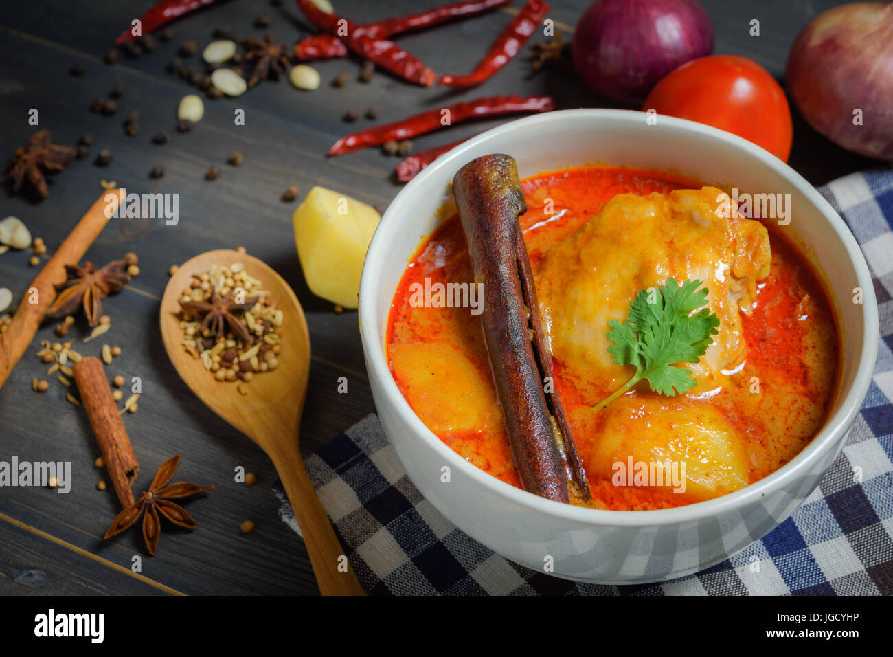 Close up Chicken massaman curry with herb on wooden background, Thai local food Stock Photo