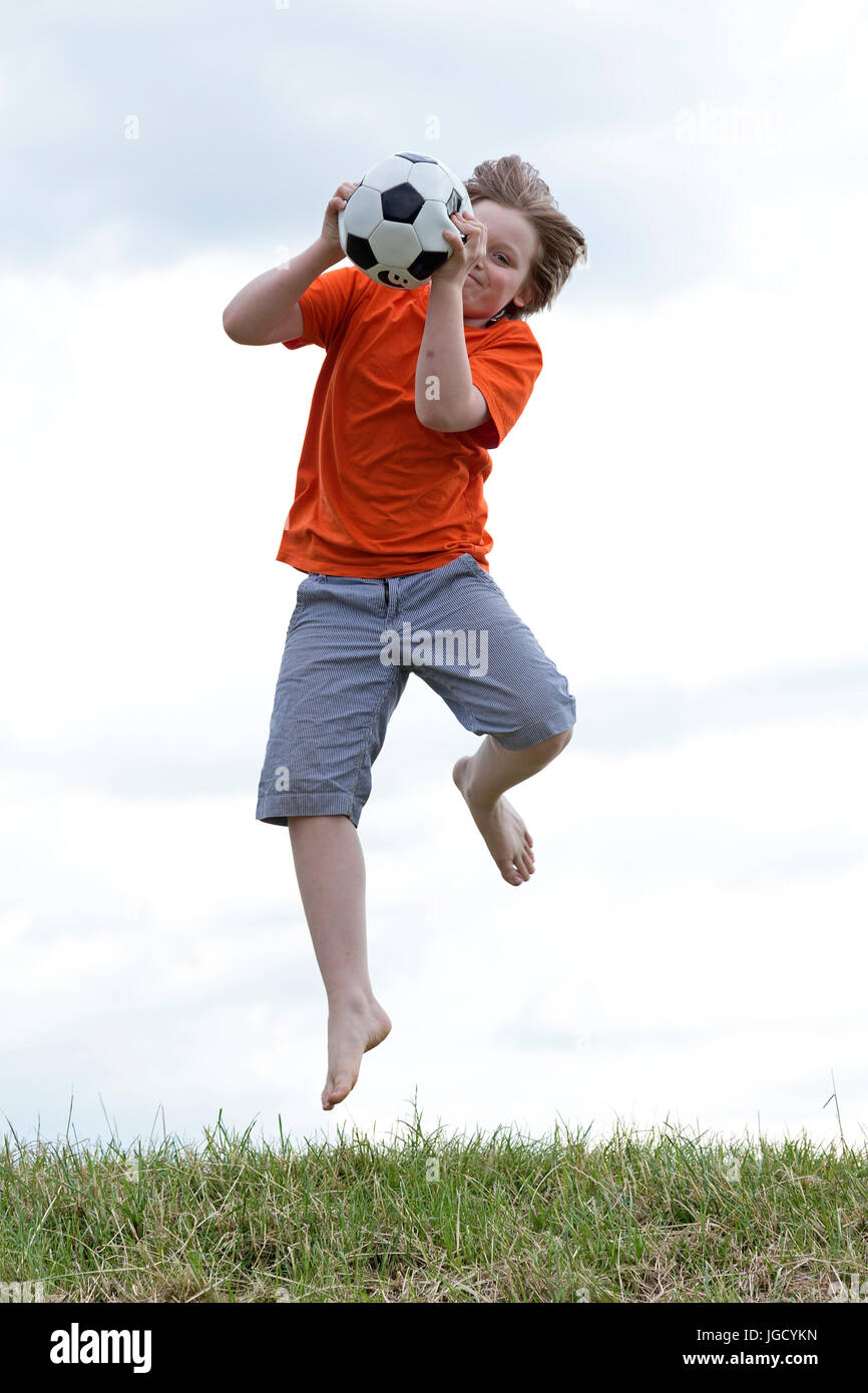 young boy jumping to catch a ball Stock Photo