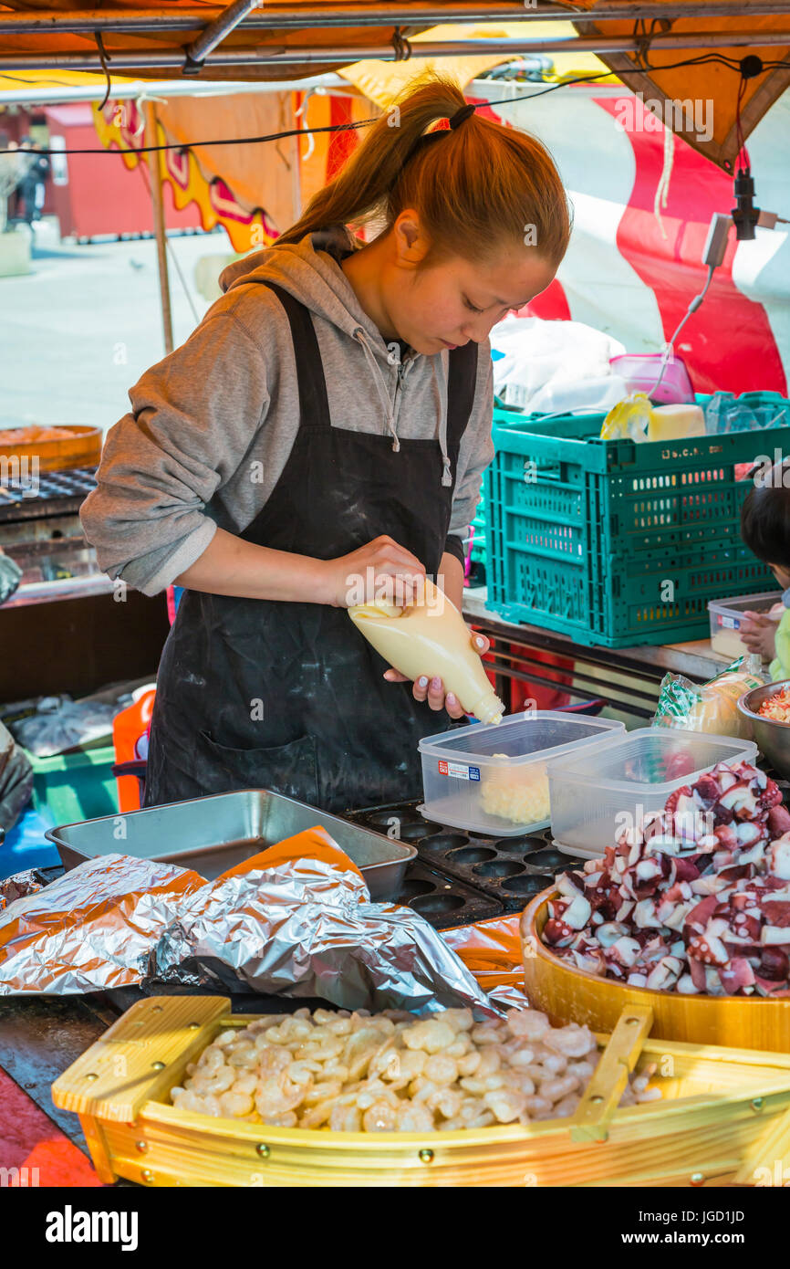 A street food vendor preparing traditional Japanese dishes in Asakusa