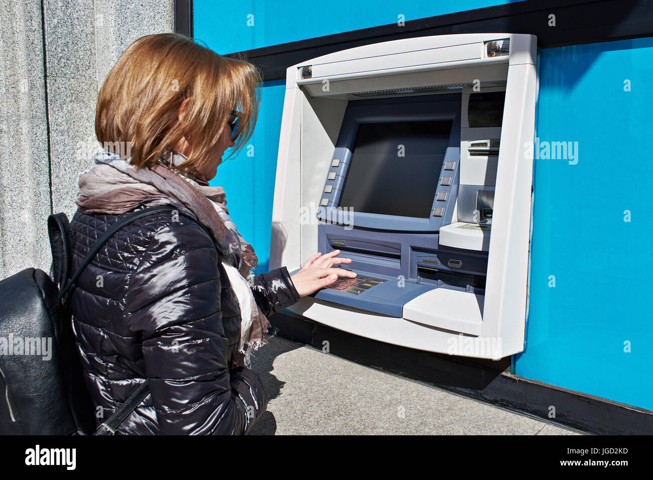 Woman enters a PIN code in an ATM Stock Photo - Alamy