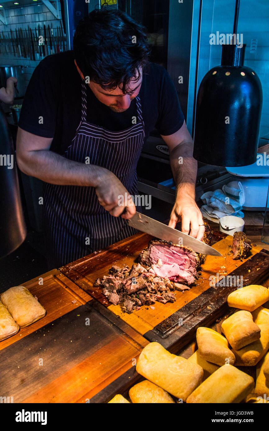 Cutting prime rib for sandwiches at Meat and Bread Restaurant, Gastown, Vancouver, Canada Stock Photo