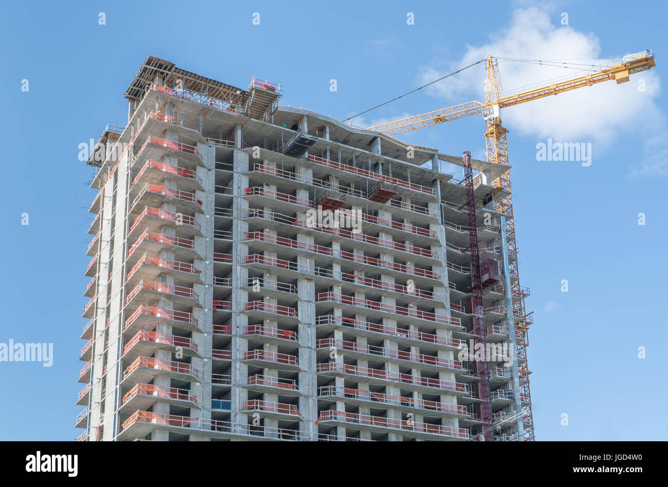 High-Rise condominium construction site with heavy crane. Stock Photo