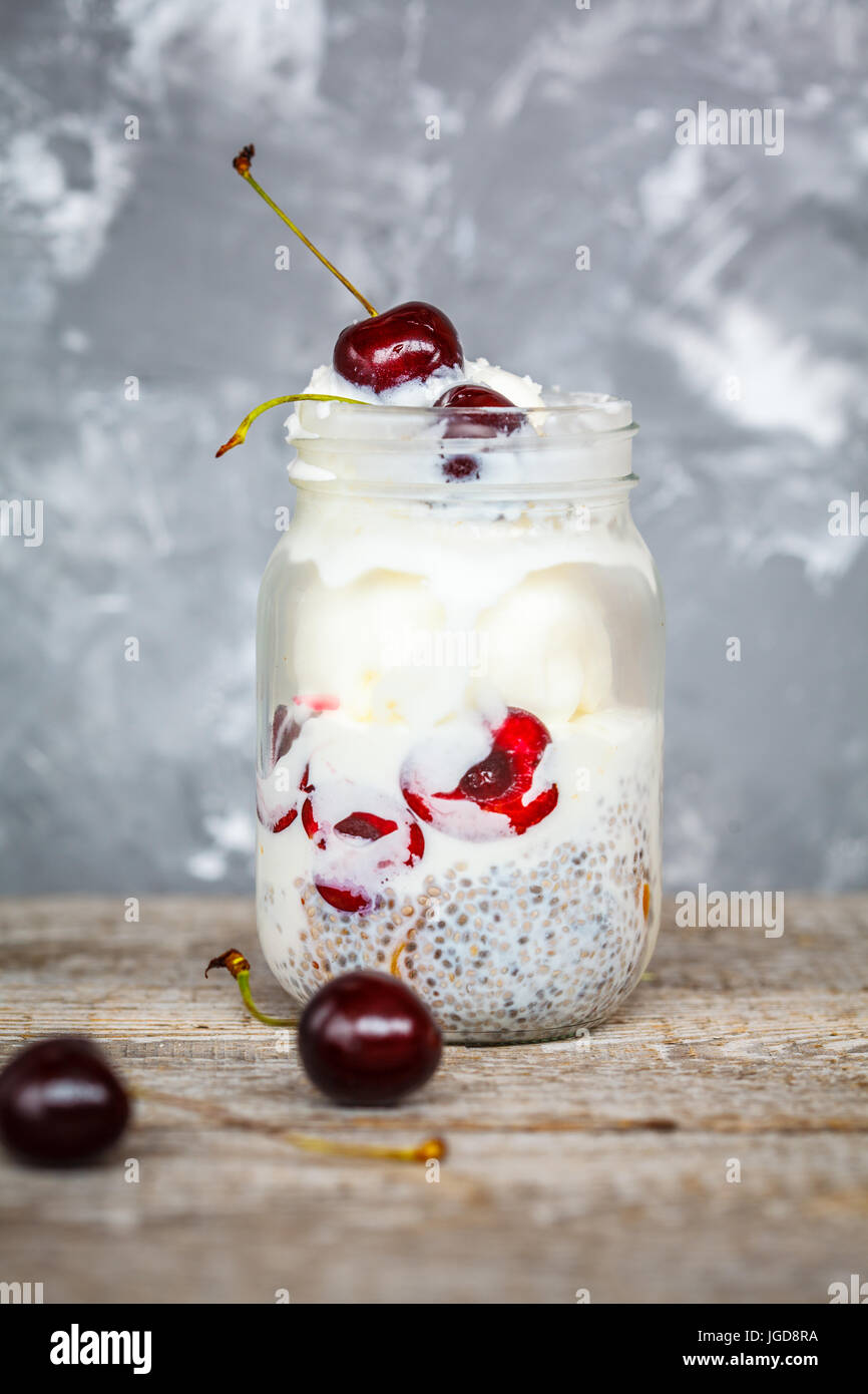Vegan ice cream with chia seeds and cherries in a jar. Love for a healthy vegan food concept. Stock Photo