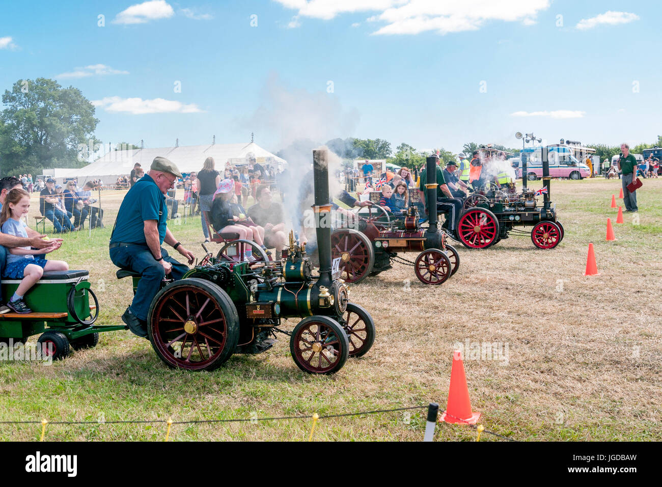 Children enjoying a race of miniature scale model traction engines at a steam rally Stock Photo