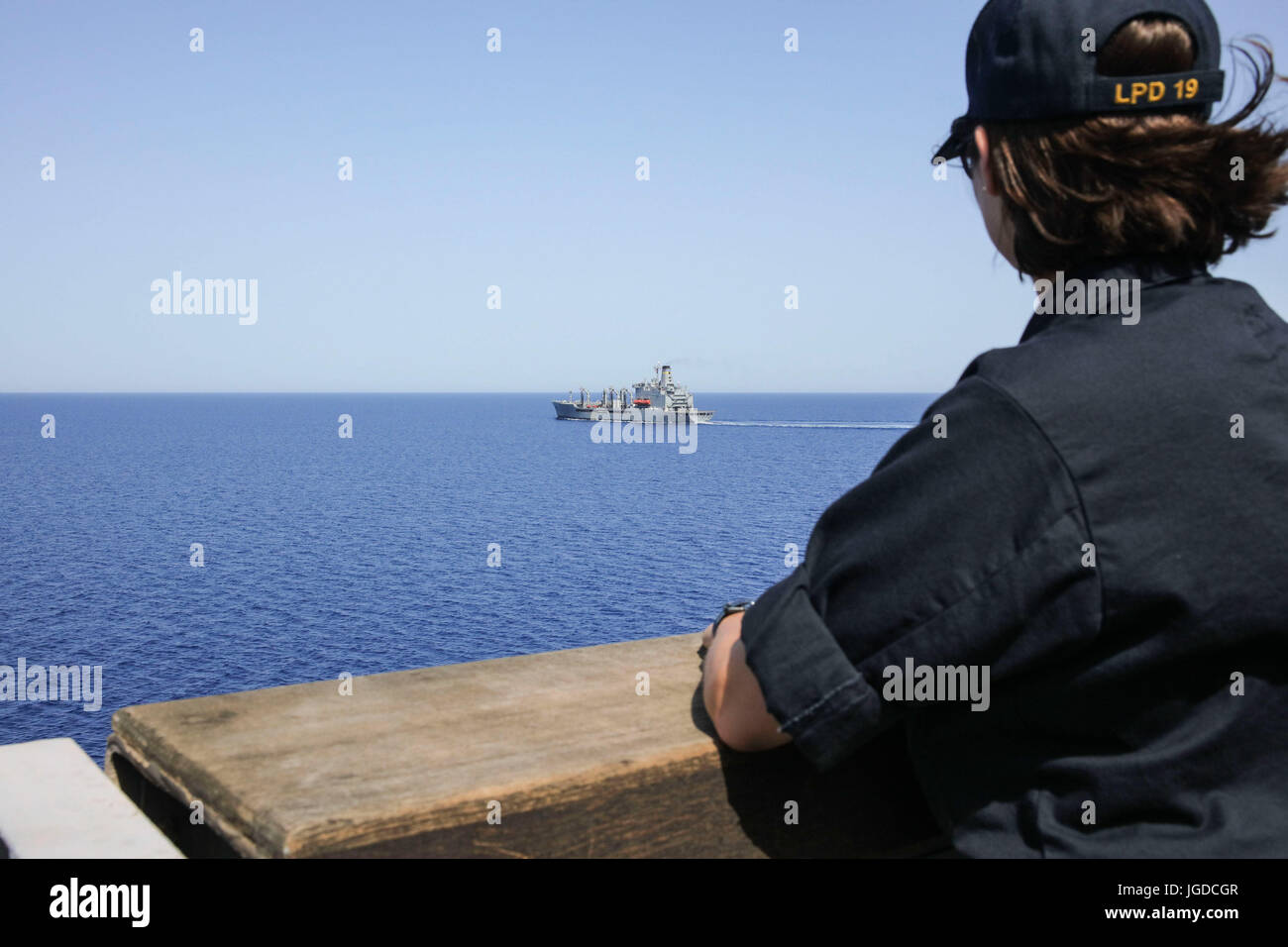 170629-N-FM530-134  MEDITERRANEAN SEA (June 29, 2017) Ensign Lauren Symmes, assigned to the San Antonio-class amphibious transport dock ship USS Mesa Verde (LPD 19), watches as fleet replenishment oiler USNS Big Horn (T-AO 198) sails away after a replenishment-at-sea June 29, 2017. The ship is deployed with the Bataan Amphibious Ready Group and 24th Marine Expeditionary Unit to support maritime security operations and theater security cooperation efforts in the U.S. 6th Fleet and U.S. 5th Fleet areas of operations. (U.S. Navy photo by Mass Communication Specialist 2nd Class Brent Pyfrom/Releas Stock Photo