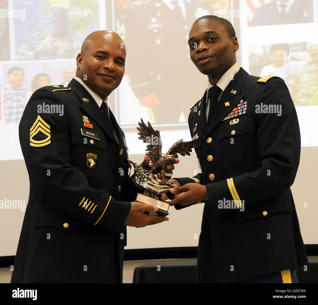 Capt. Eric Moton (right), chief, Finance Division for the U.S. Army Reserve’s 99th Regional Support Command, hands an award to Sgt. 1st Class Christopher Moore Nov. 5, 2016 during a retirement ceremony for Moore.  Moton earned his Ph.D. in business administration in 2016, joining a select group of Army Reserve Soldiers who have pursued higher education. Of all doctorates in the U.S. Army, 75 percent reside in the U.S. Army Reserve. Of all master’s degrees in the U.S. Army, 50 percent reside in the U.S. Army Reserve. Having such a highly educated force helps America’s Army Reserve remain the mo Stock Photo