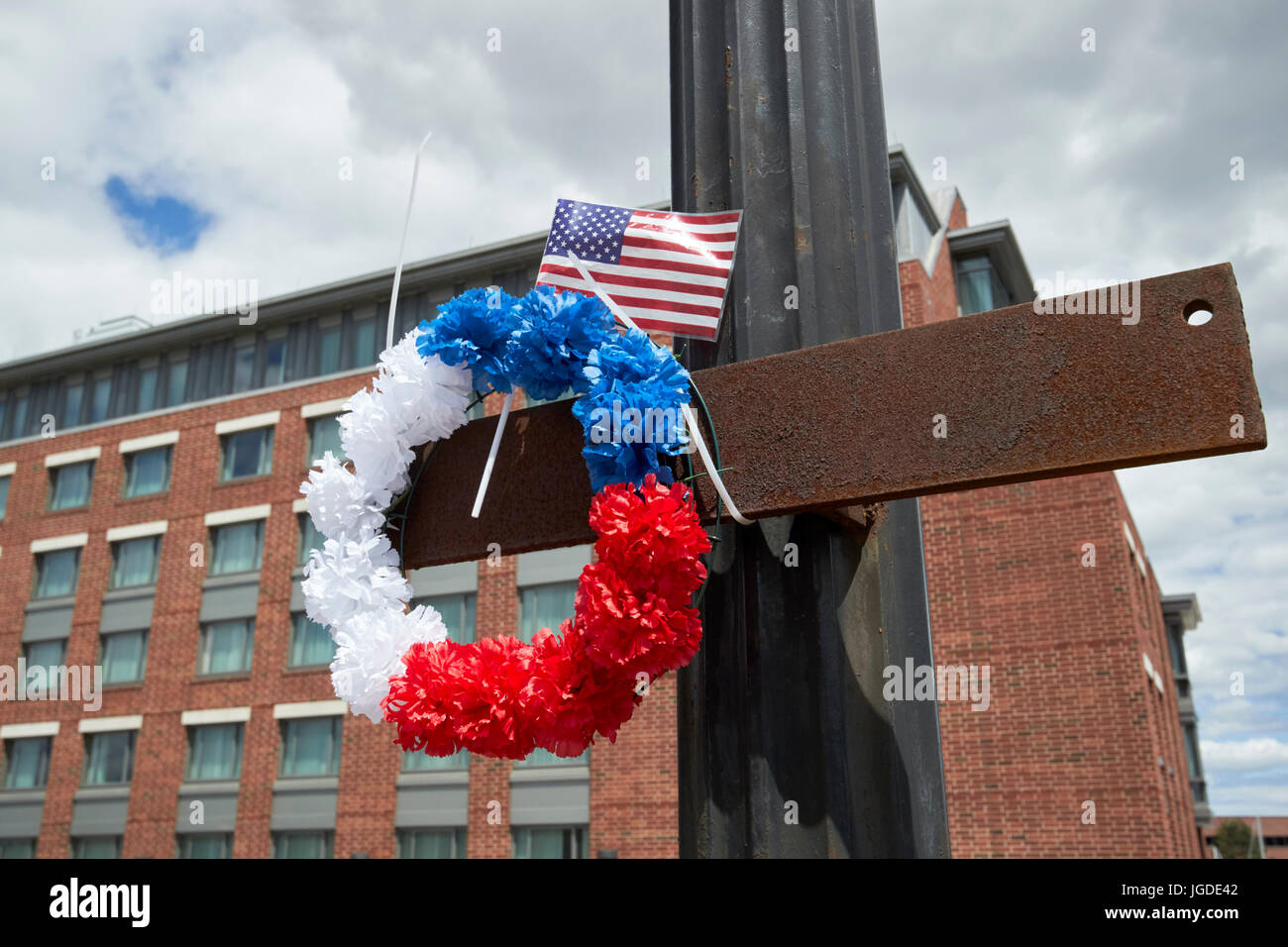red white and blue memorial circular wreath and us flag memorial for firefighter lt steve minehan at the site of warehouse fire Boston USA Stock Photo
